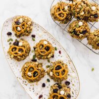 Overhead view of peanut butter banana oatmeal cookies on a plate and wire rack.