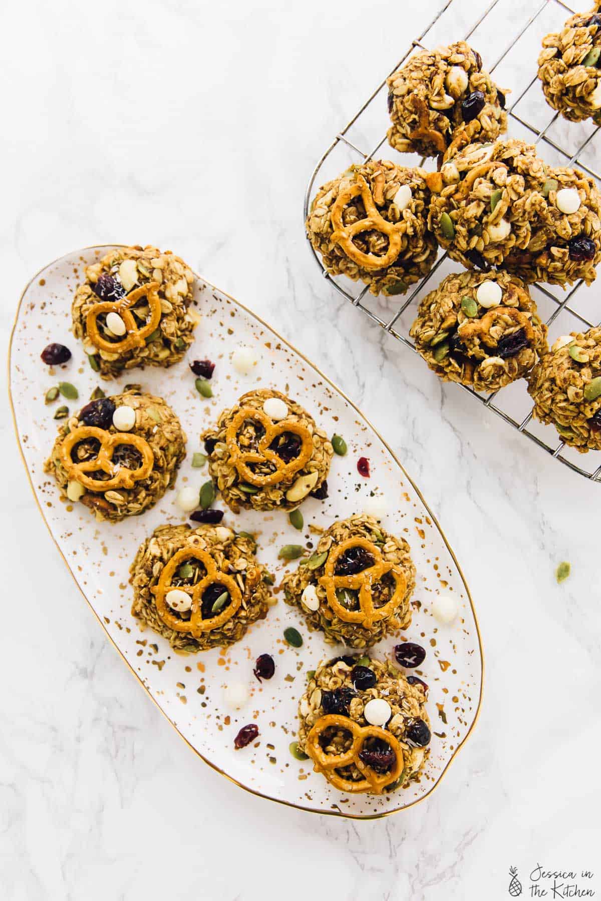 Overhead view of peanut butter banana oatmeal cookies on a plate and wire rack.