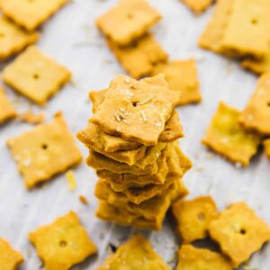 A pile of herbed parmesan crackers, surrounded by more crackers.