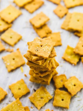 A pile of herbed parmesan crackers, surrounded by more crackers.