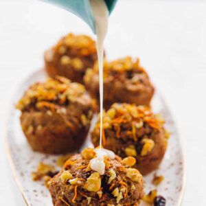 Icing being poured on a carrot cake muffin.