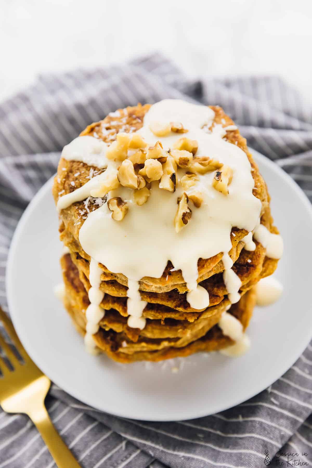 Top down view of vegan carrot cake pancakes, drizzled with sauce. 