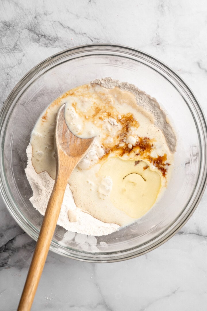 These carrot cake pancakes are fluffy, warmly spiced, and topped with an irresistible maple cream cheese drizzle. A cozy vegan breakfast! Liquid ingredients added to dry ingredients in mixing bowl.