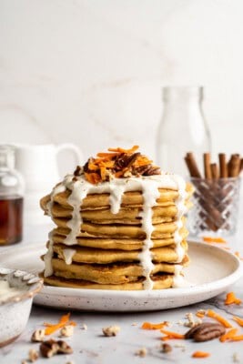 Plate of carrot cake pancakes with maple cream cheese drizzle.
