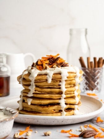 Plate of carrot cake pancakes with maple cream cheese drizzle.
