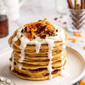 Stack of carrot cake pancakes with maple cream cheese drizzle.