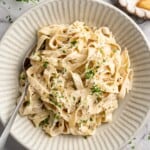 Overhead view of vegan garlic Alfredo pasta in bowl with spoon
