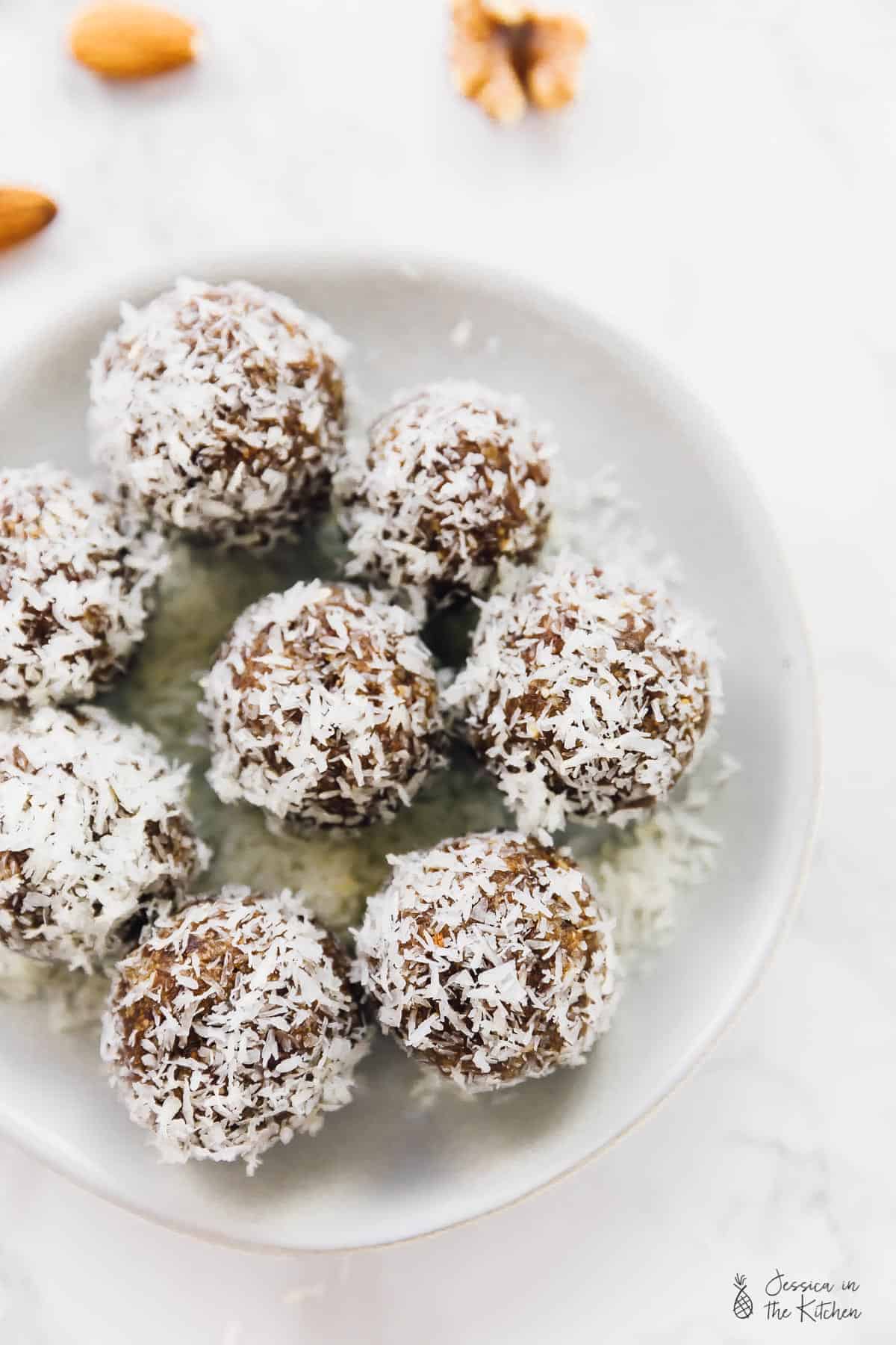 Top down view of coconut lemon energy bites in a white bowl.