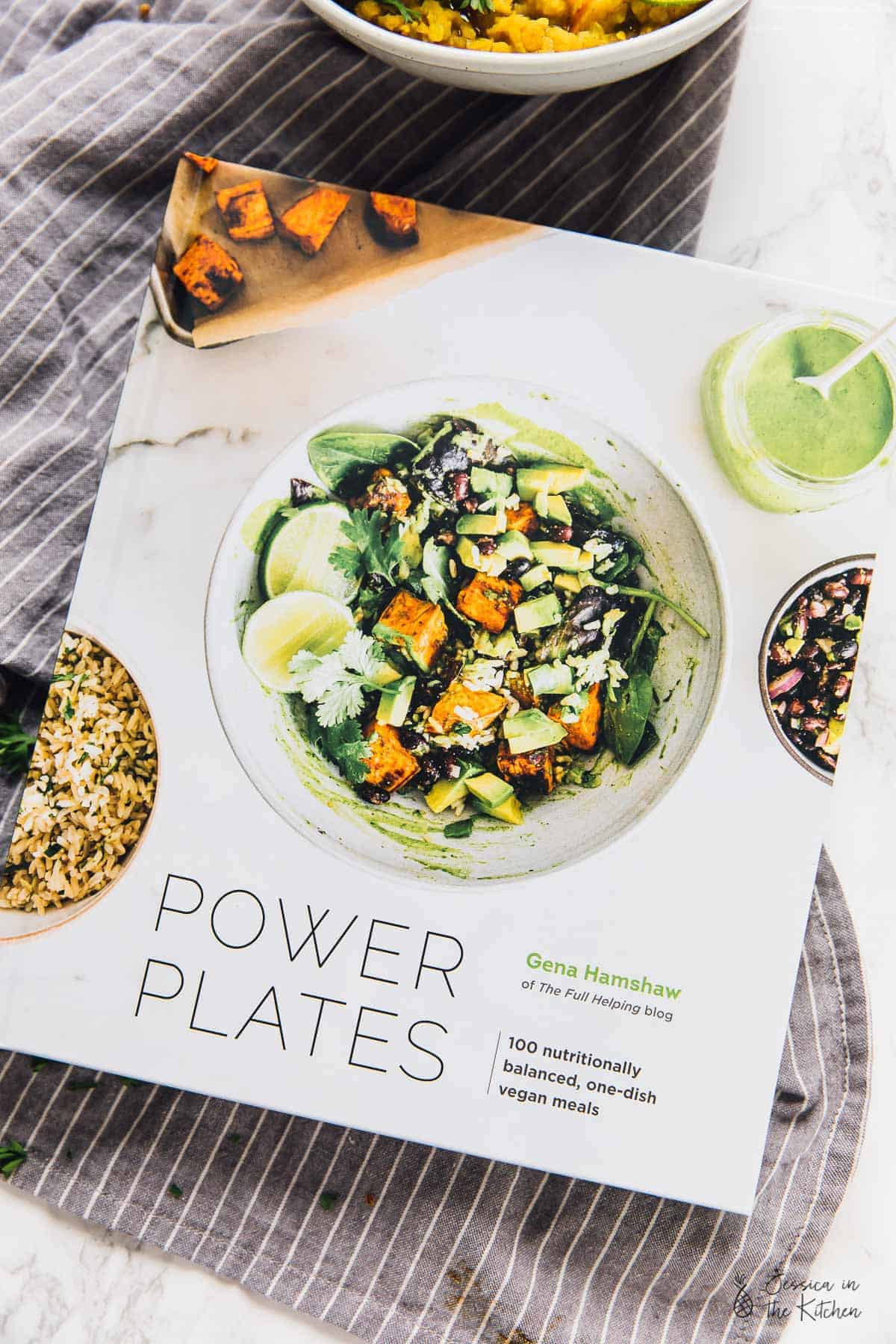 Close up of a cookbook called "Power Plates," with a picture of a tofu and avocado salad on the front