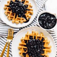 Overhead shot of lemon poppyseed waffles covered with blueberry sauce.