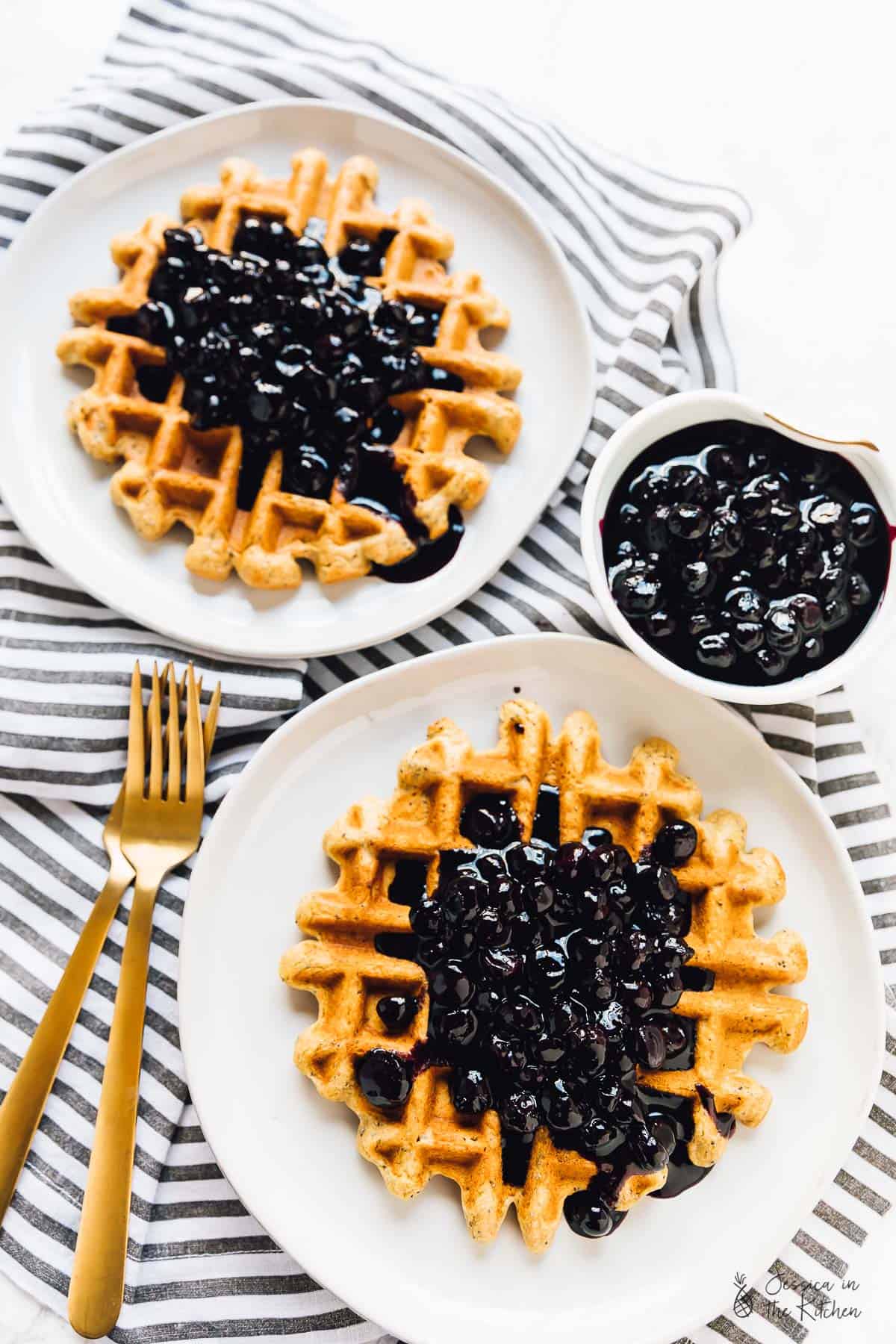 Top down view of lemon poppyseed waffles with blueberry sauce on top. 