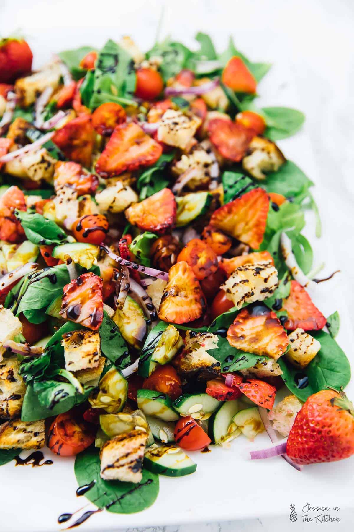 Strawberry panzanella salad drizzled in balsamic vinegar. 