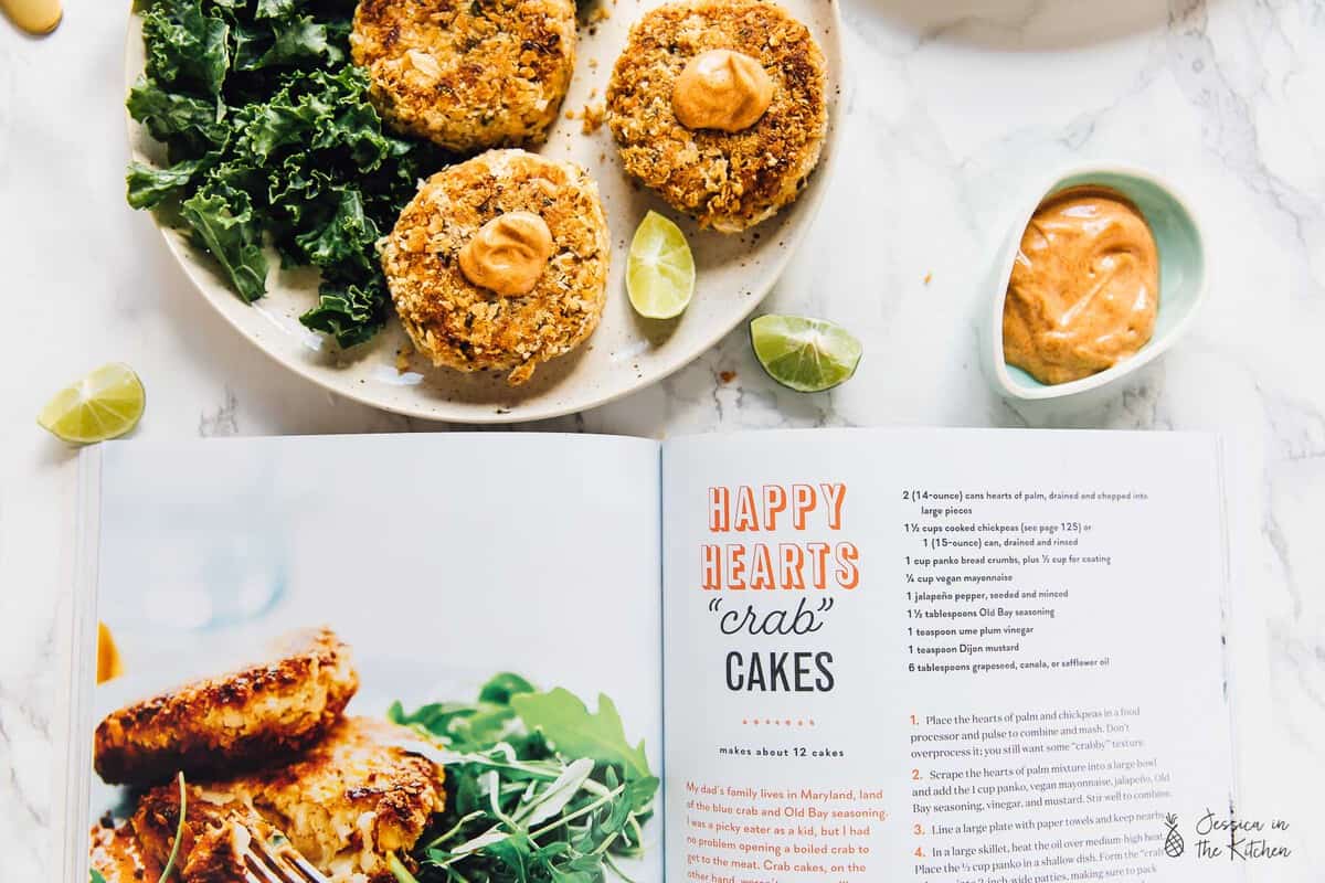 Top down view vegan crab cakes next to an open cook book.