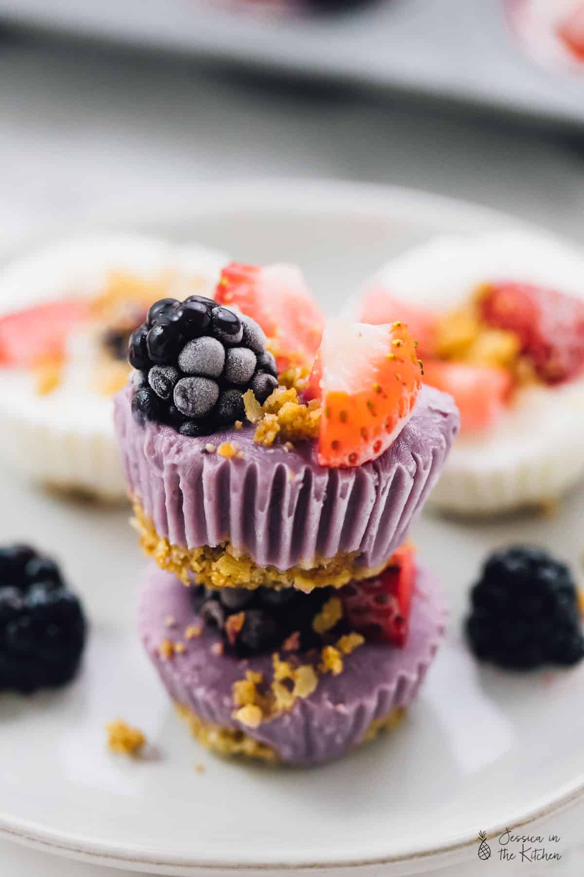A stack of frozen yogurt granola cups, surrounded by blackberries. 