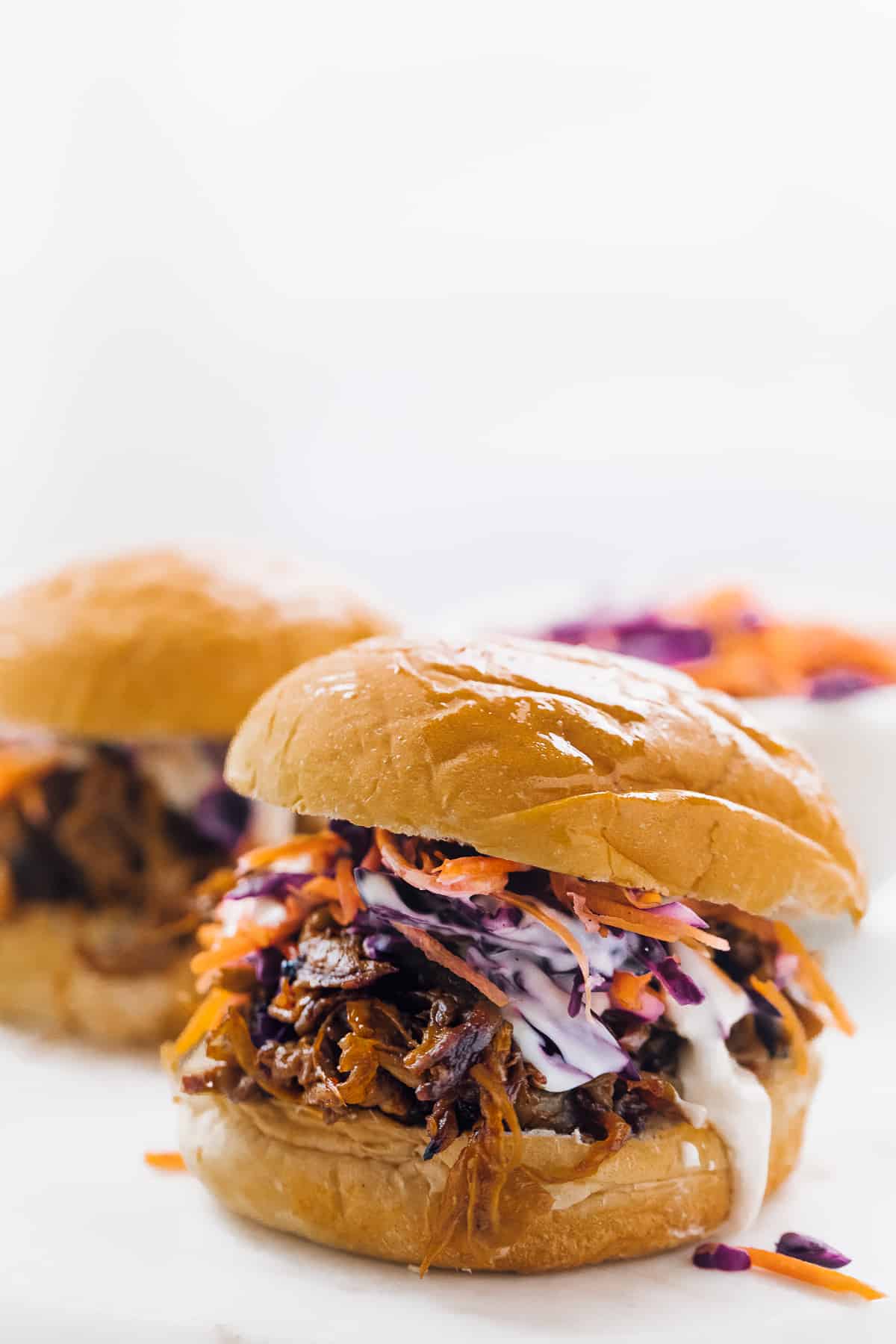 side view of pulled mushroom sandwiches on buns with cole slaw 