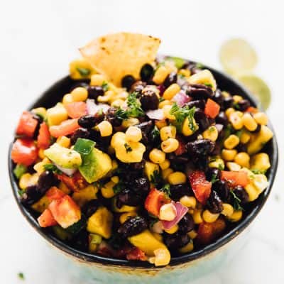 A bowl of chilled black bean and corn salsa with spicy jalapeños and creamy avocado.
