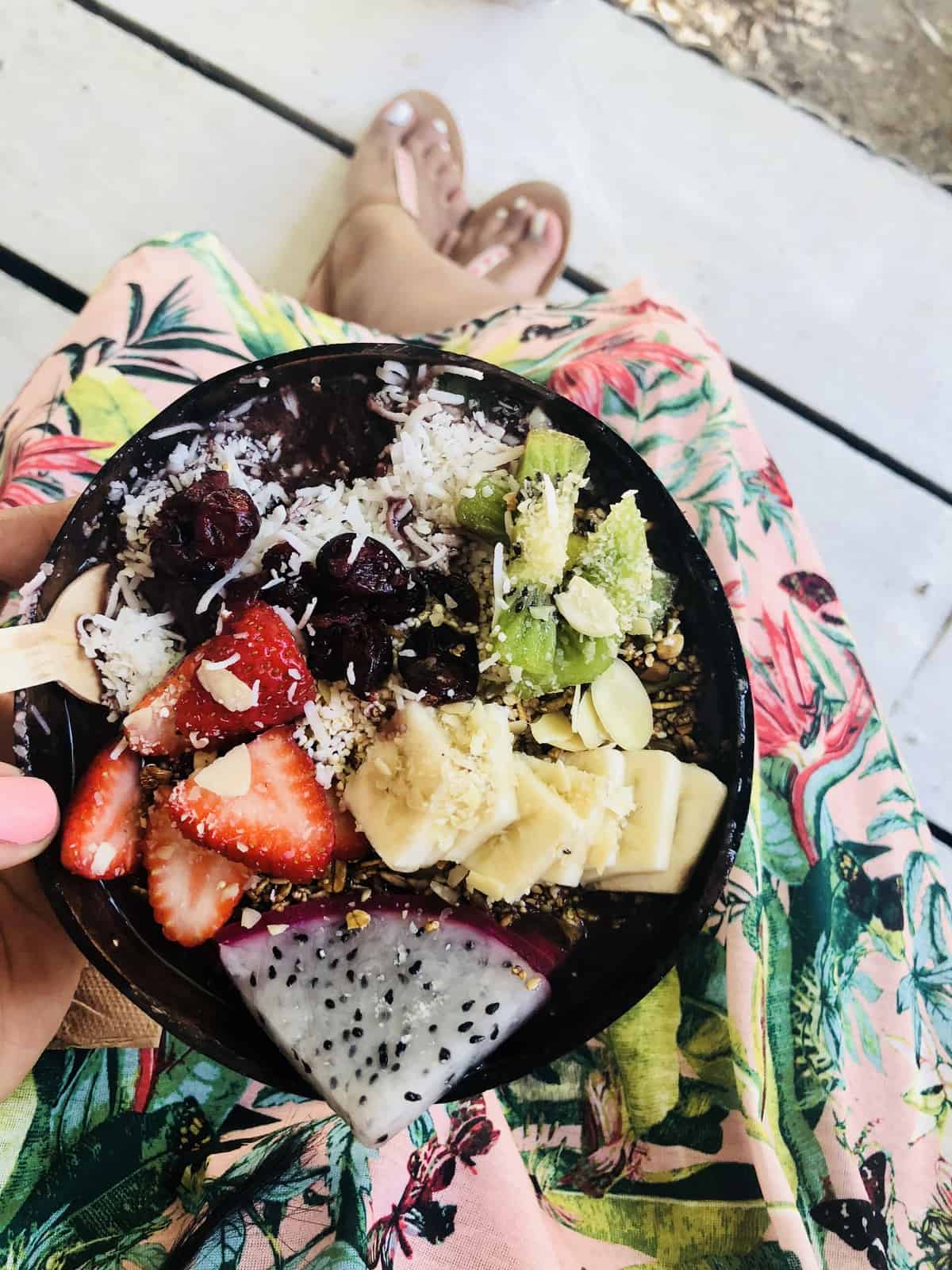 Top down shot of a a breakfast, with chopped strawberries, kiwis and dragon fruit. 