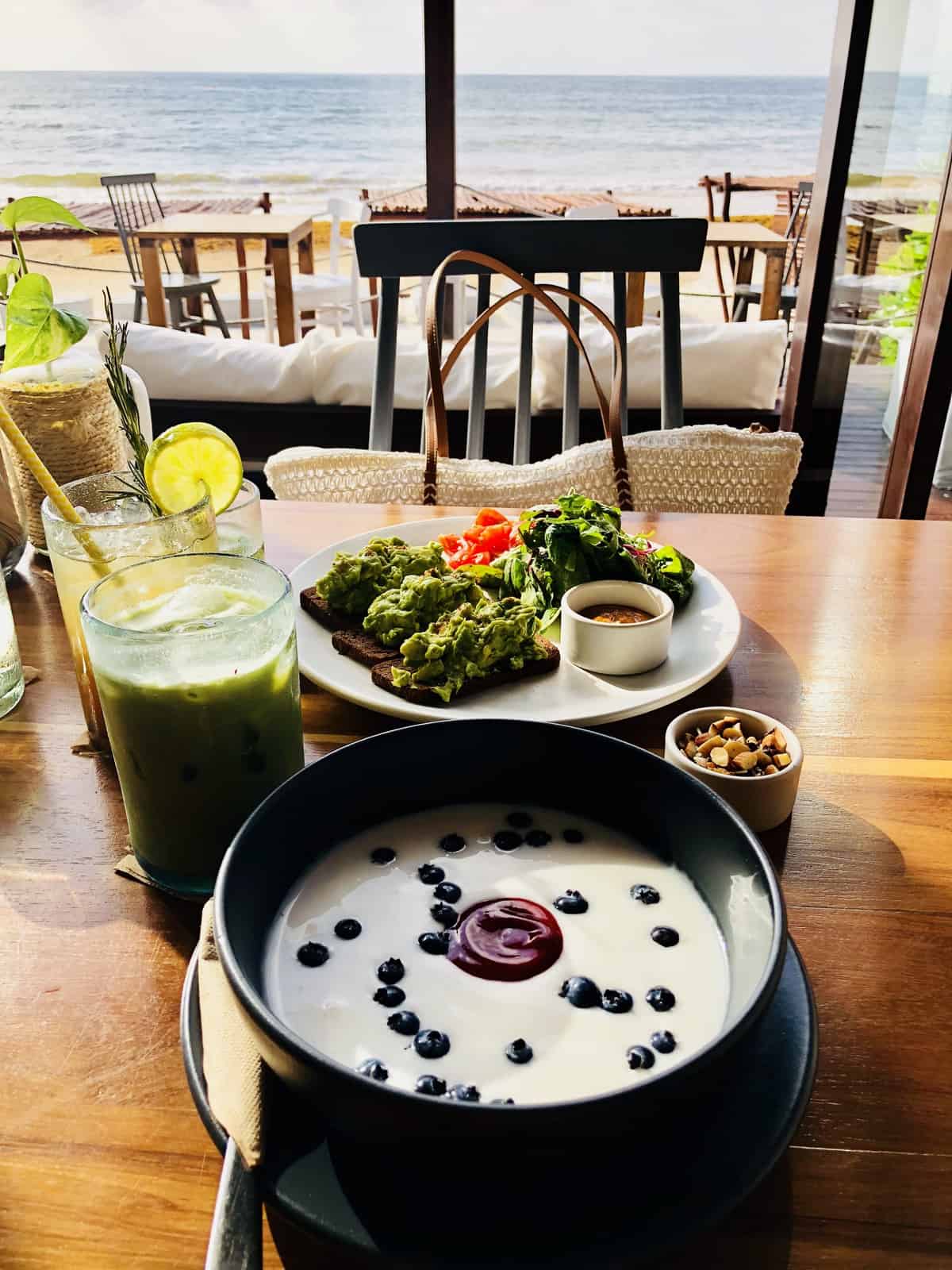 A bowlof soup on a restaurant table, by the beach. 