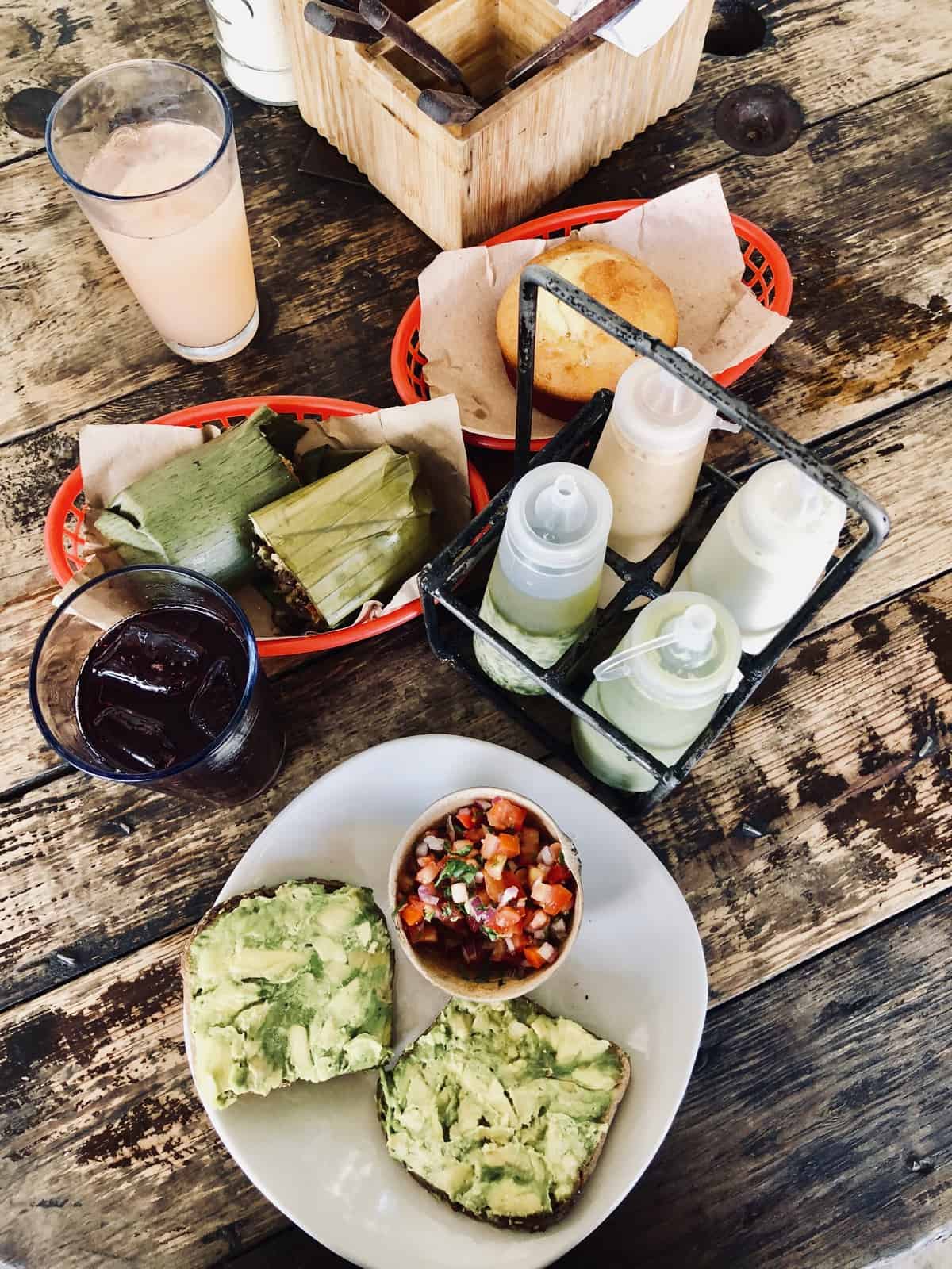 Overhead view of plates and baskets of food on a wooden table. 