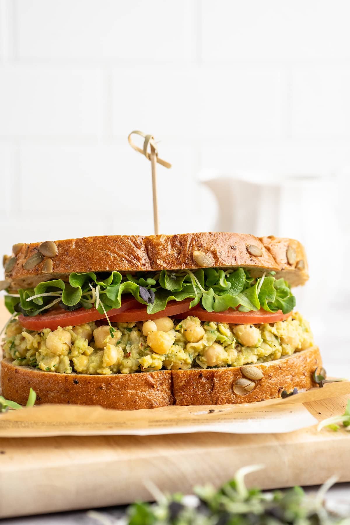 Smashed chickpea avocado sandwich on cutting board