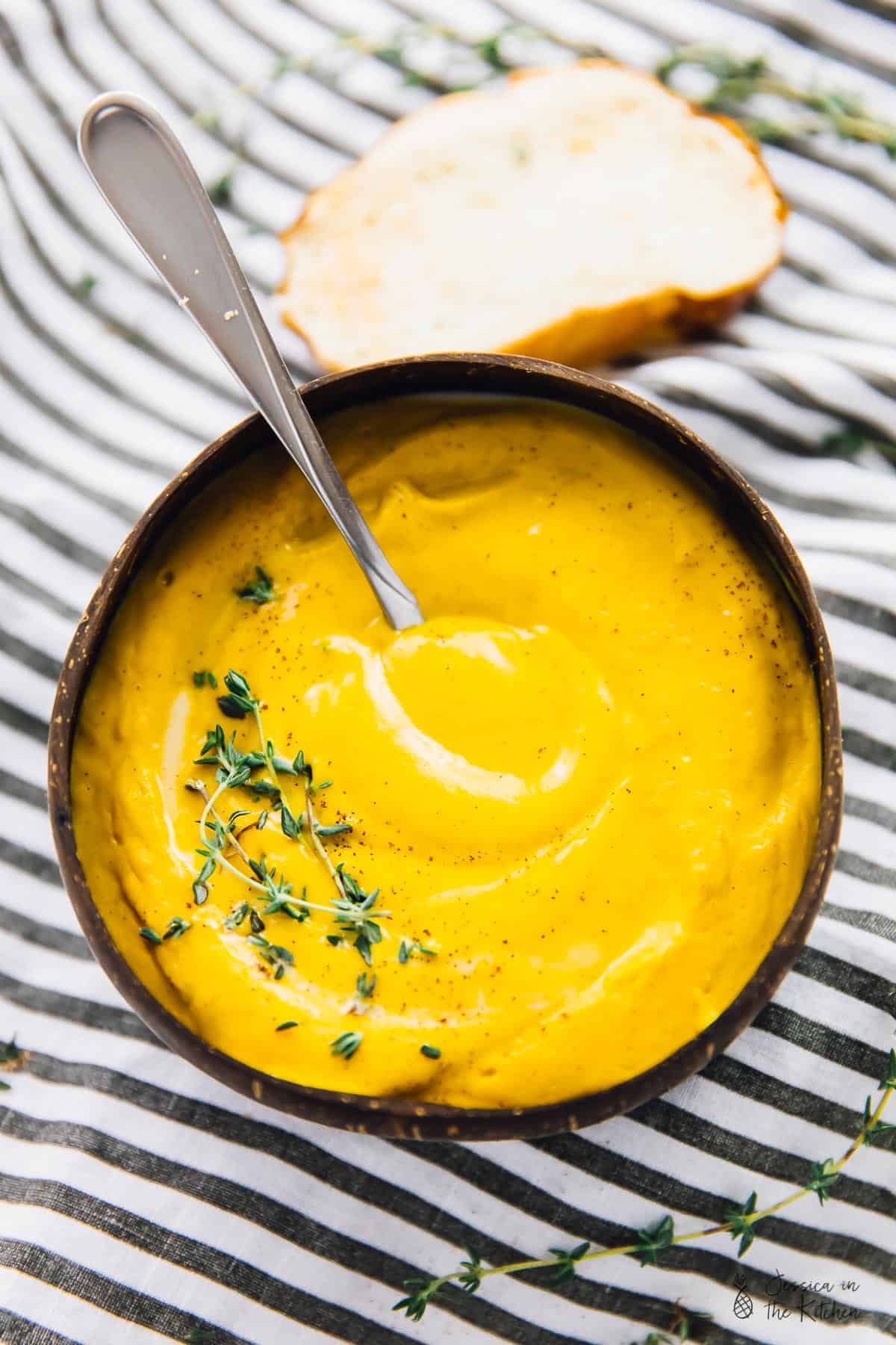 Top down shot of fall soup in a bowl, with a spoon in it. 