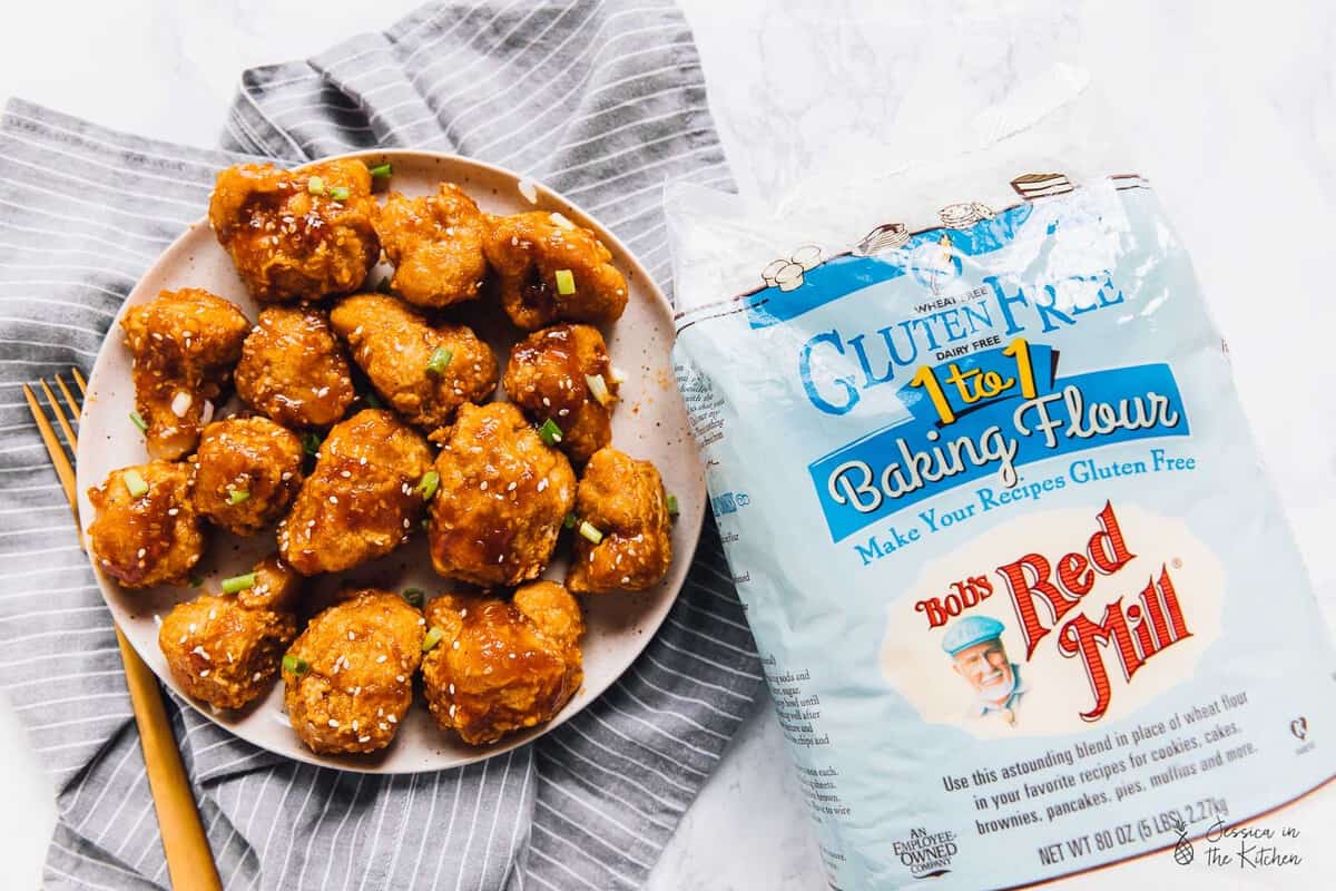 Top down view of cauliflower bites next to a pack of baking flour. 