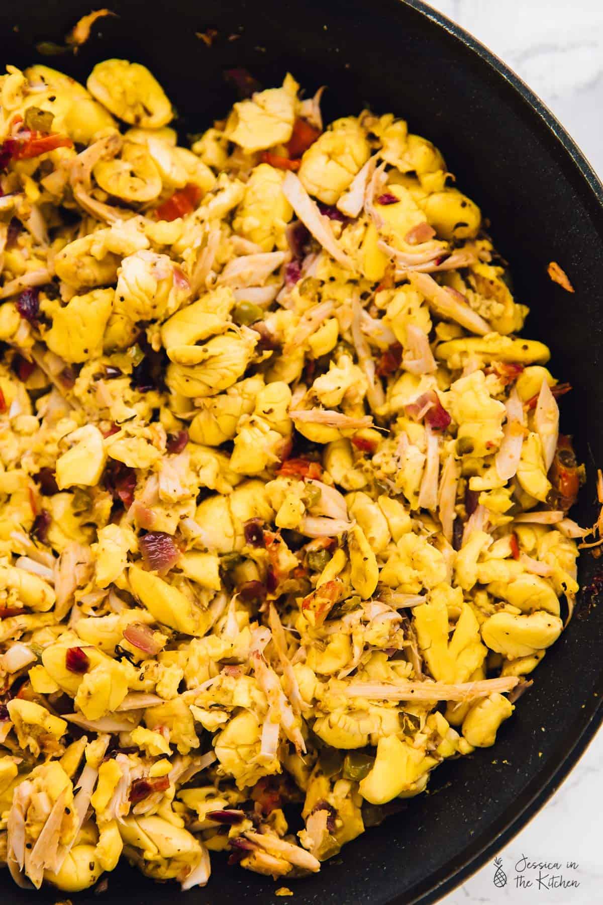 Top down view of vegan ackee and saltfish, in a black skillet. 