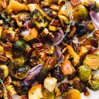 Maple roasted brussels sprouts with apples and pecans on a large white plate.