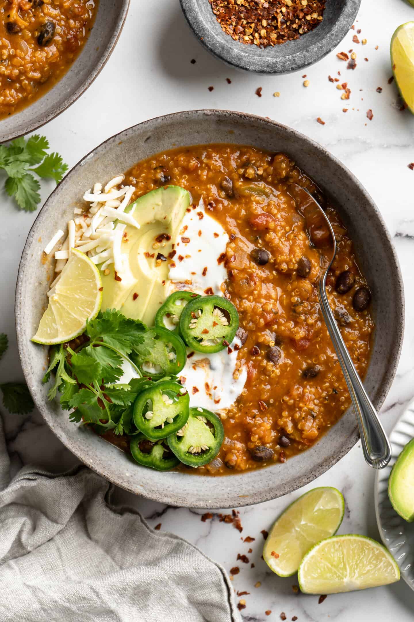 Close up of pumpkin chili topped with jalapenos and avocado