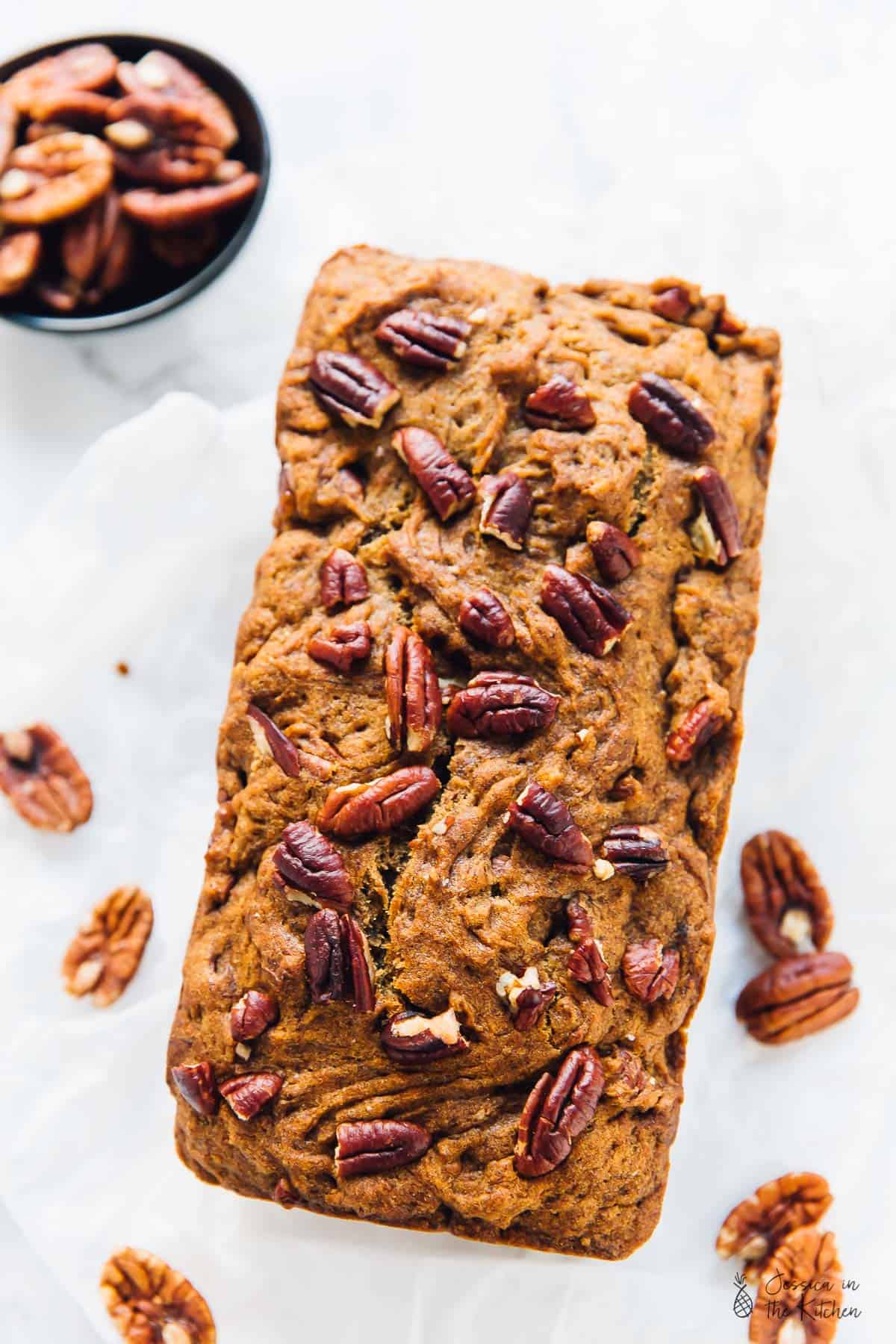 Overhead shot of banana bread, topped with pecans.