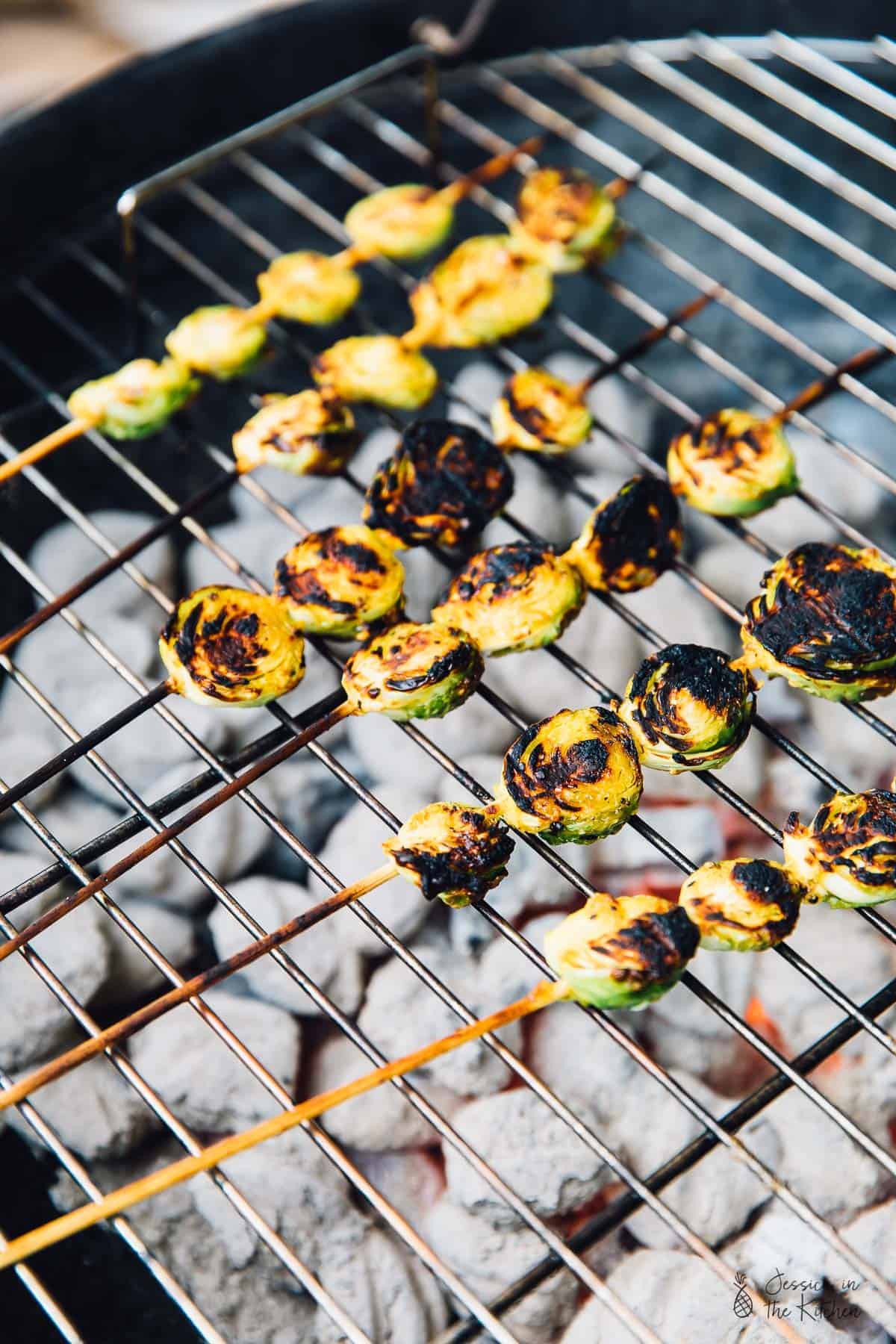 Skewers of maple mustard brussels sprouts on a bbq grill. 