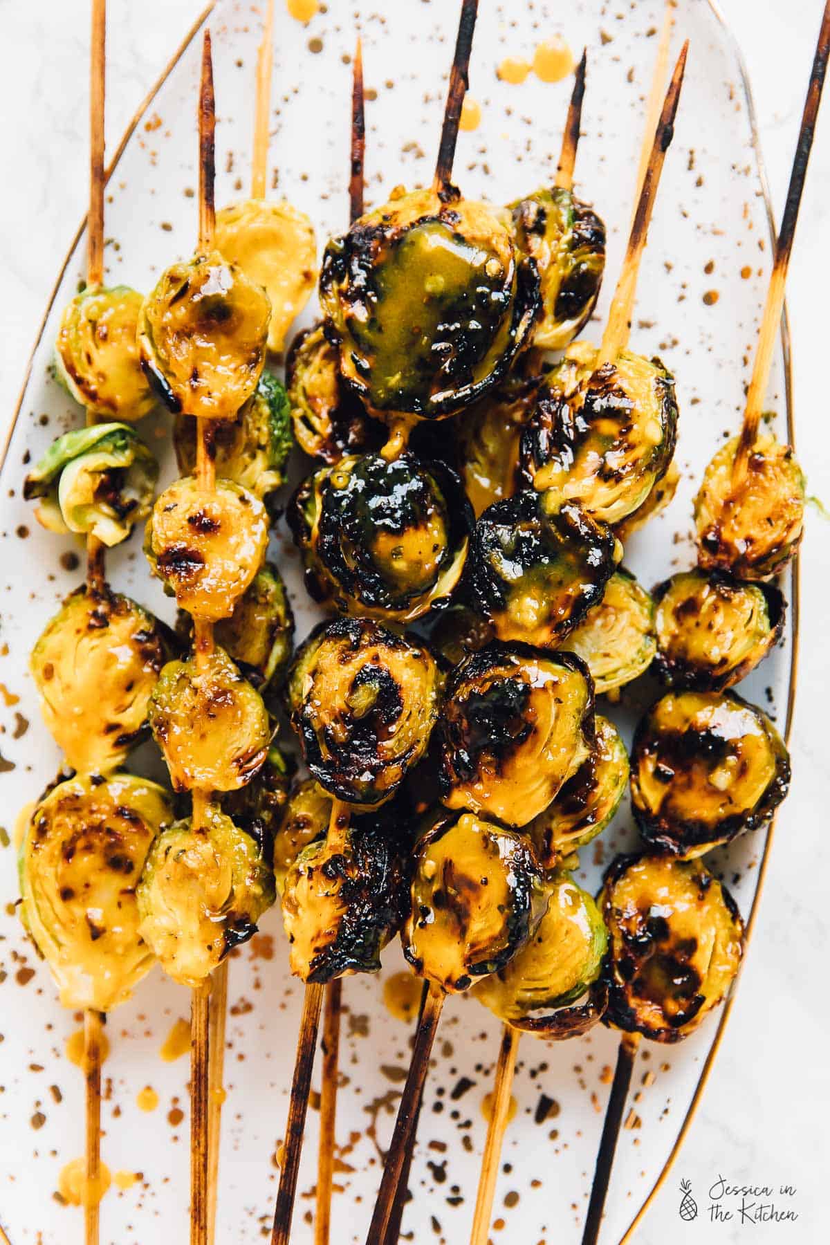 Top down shot of grilled maple mustard brussels sprouts on skewers. 