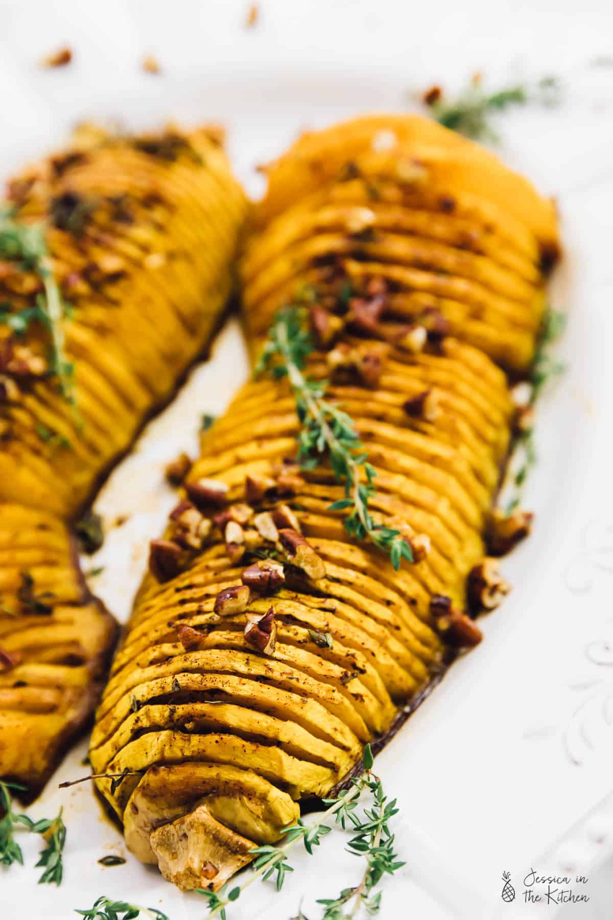 Hasselback butternut squash, topped with pecans and herbs.