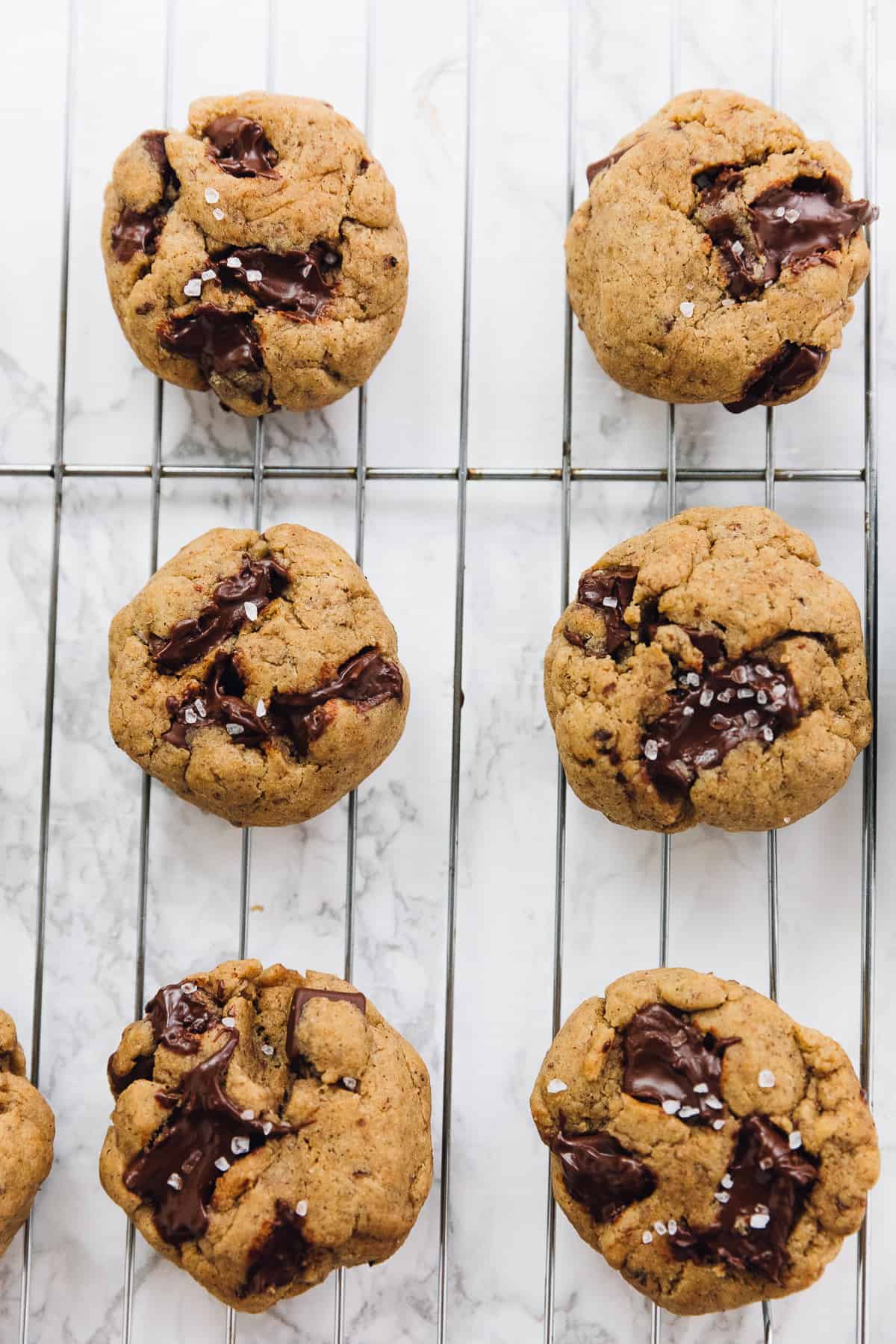 Salted chocolate chip tahini cookies on a wire rack