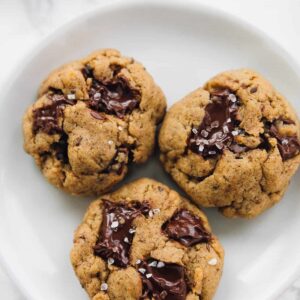 3 Salted chocolate chip tahini cookies on a plate close up