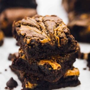 A stack of vegan brownies on a white table top.