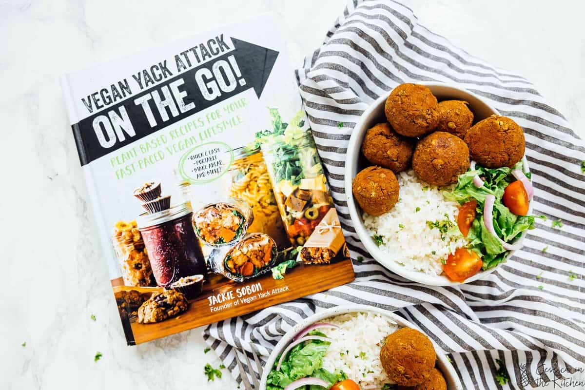 Two bowls of lentil balls next to a vegan cook book. 