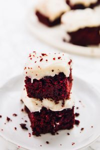 Red velvet brownies stacked on a plate.