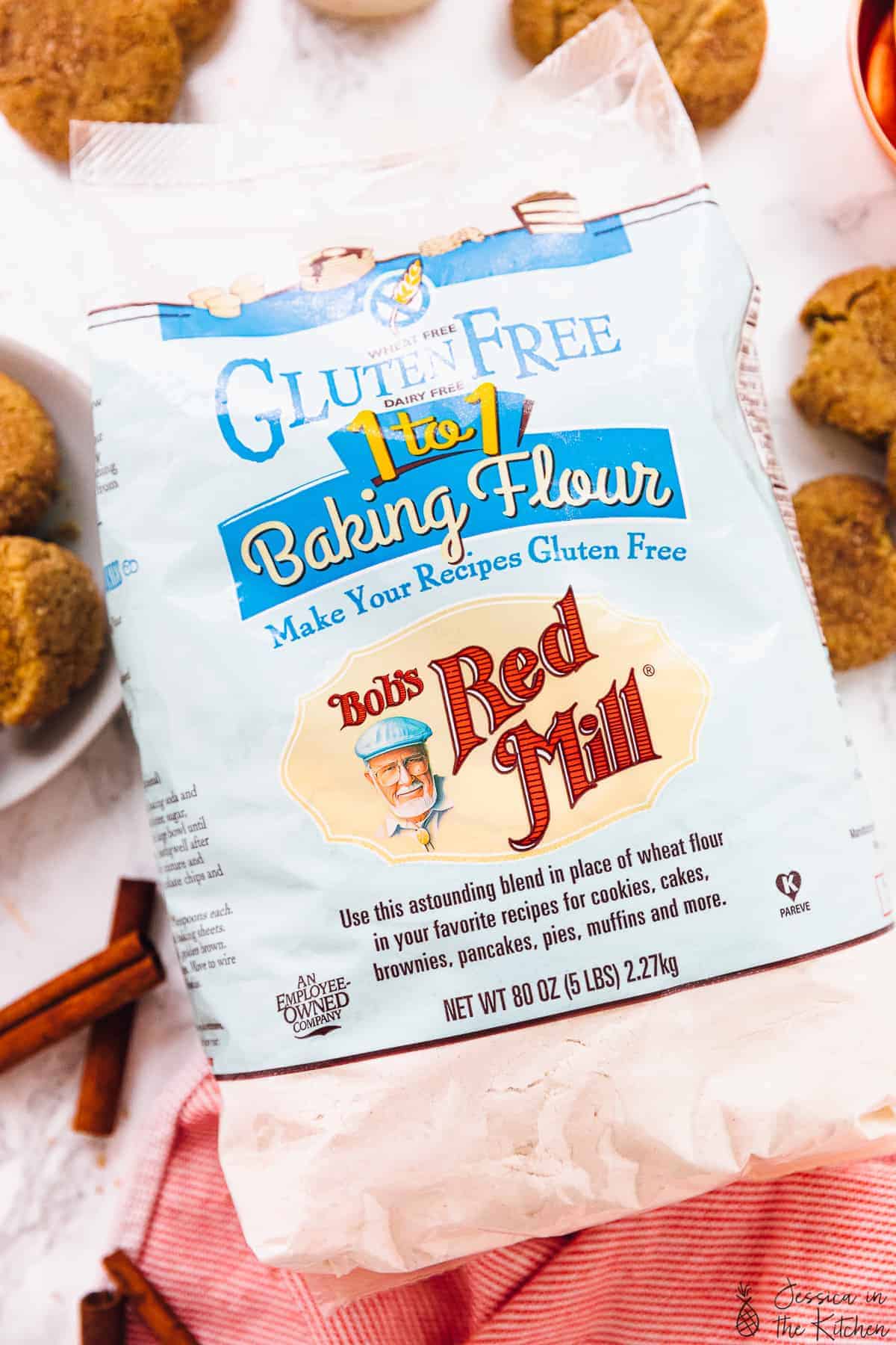 Bob's Red Mill Gluten Free Flour surrounded by cookies and cinnamon sticks.