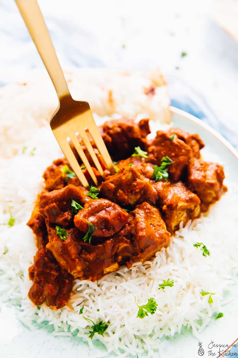 A fork digging into tofu butter chicken.