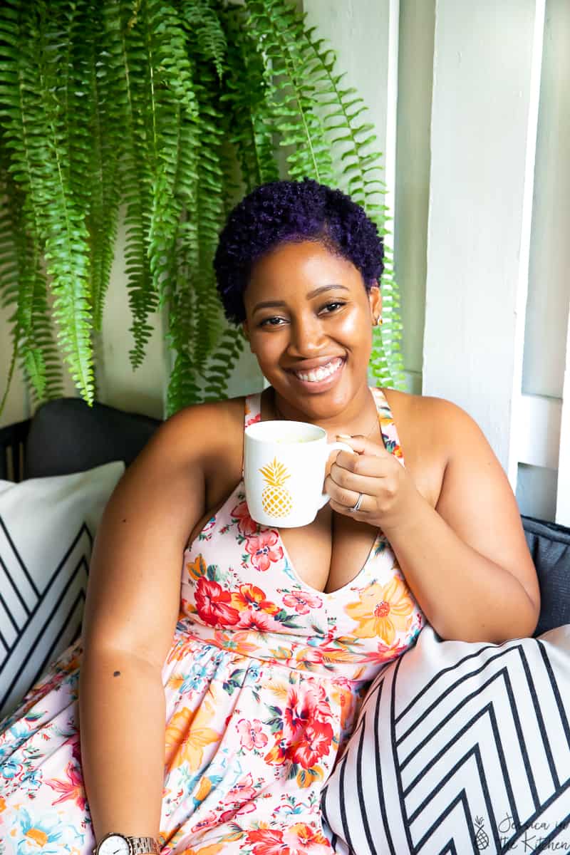 Jessica holding a mug, looking at camera. 