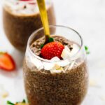 A fork sticking into a glass of chocolate chia pudding.