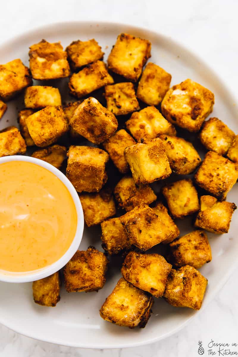 Overhead shot of baked tofu with dipping sauce on the side. 