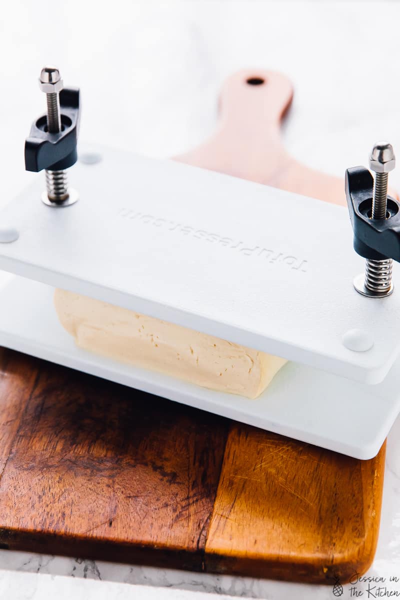 A tofu press on a wooden board. 