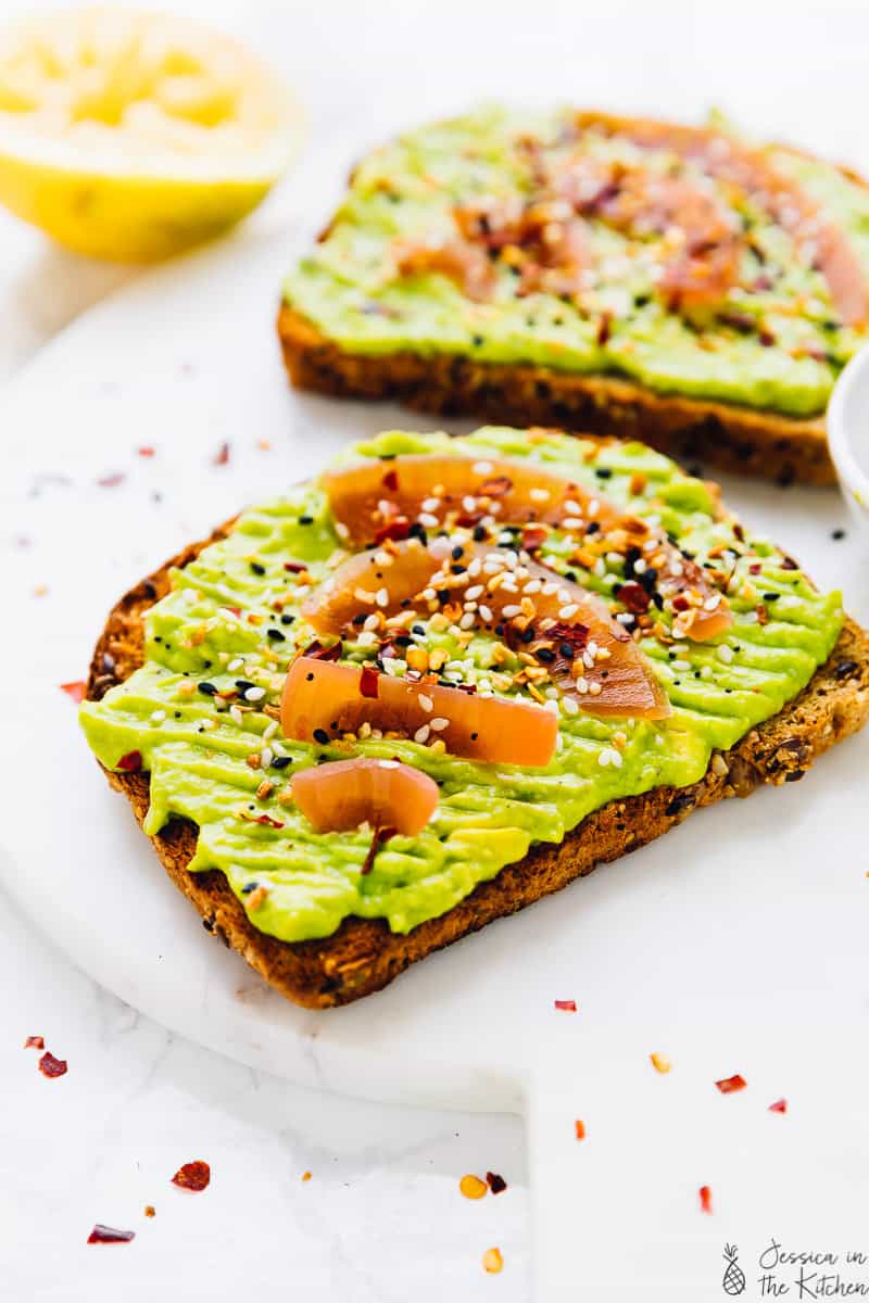 Two slices of avocado toast on marble board