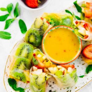 Top down view of fruit spring rolls on a platter.