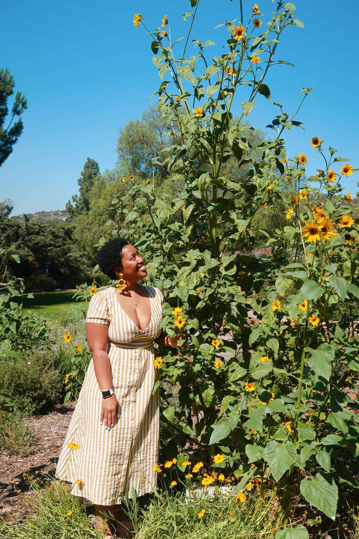 Jessica smiling at a bush.