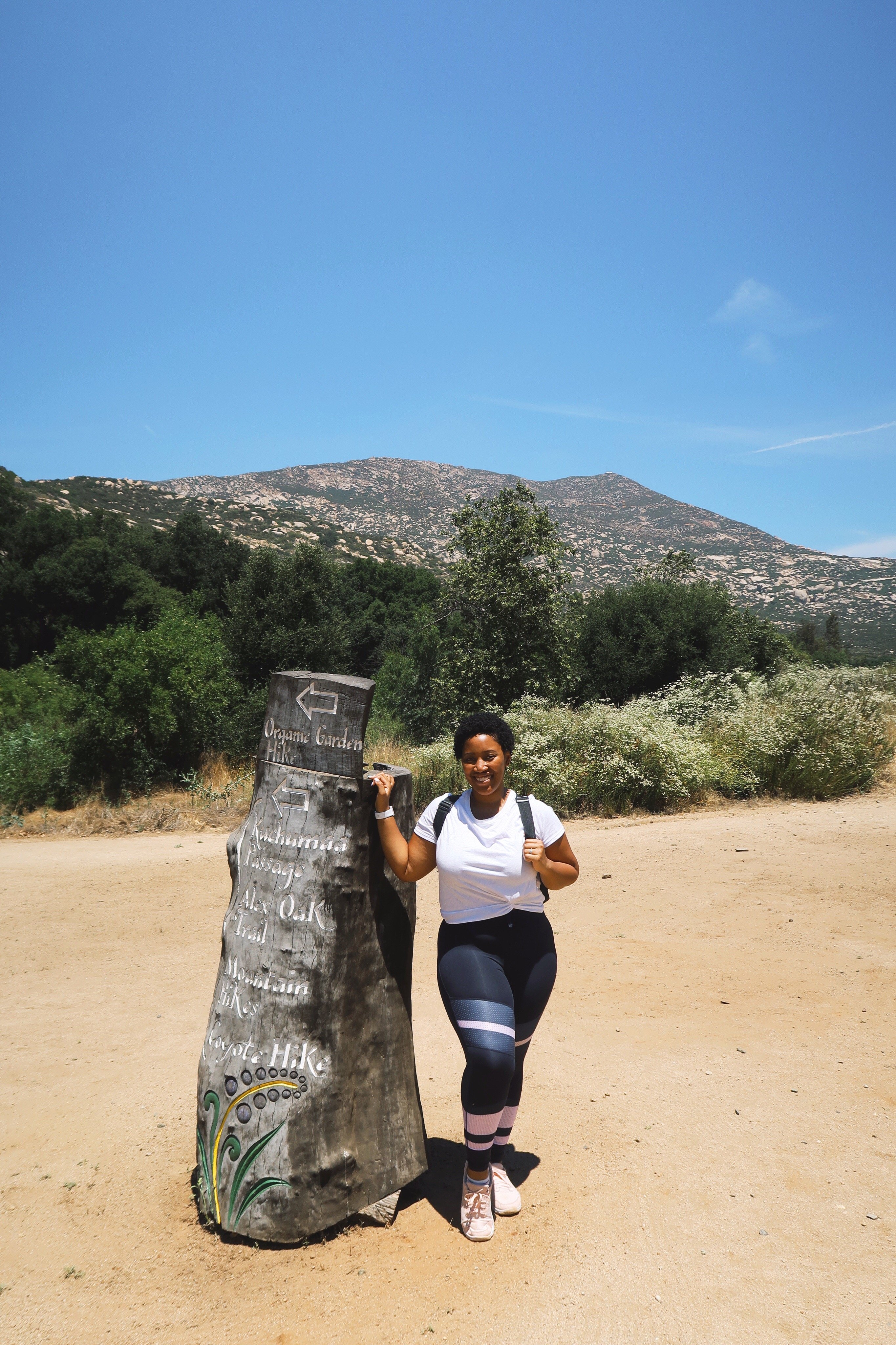 Jessica standing by a tree stump. 