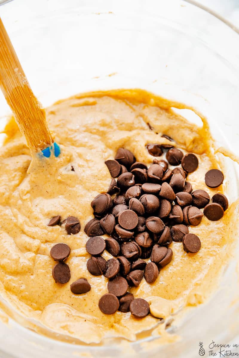 Stirring pancake batter with chocolate chips in a glass bowl. 