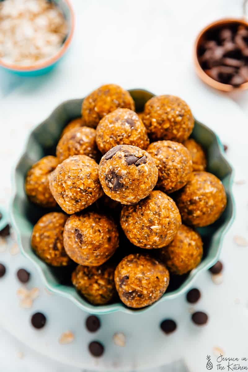 Pumpkin energy bites in a bowl in a flat lay photo.